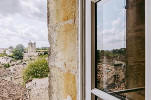 a window with a view of a city at Logis de la Cadène - Teritoria in Saint-Émilion
