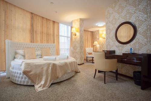 a bedroom with a bed and a desk and a mirror at Hotel Marton Palace in Kaliningrad