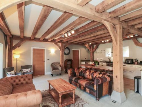 a living room with leather furniture and wooden ceilings at The Barn in York