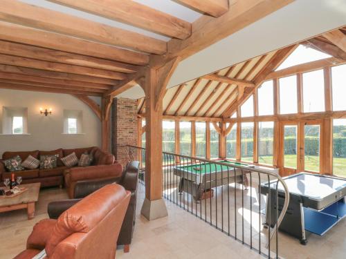a large living room with wooden ceilings and windows at The Barn in York