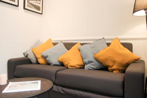 - un canapé avec des oreillers jaunes et bleus dans l'établissement Nice Studio Near Eiffel Tower, à Paris