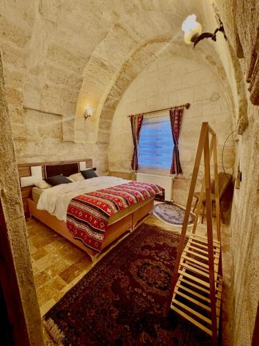 a bedroom with a large bed in a stone room at Evra Cappadocia Hotel in Nevşehir