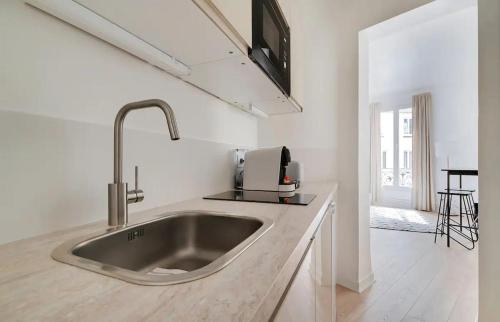 - une cuisine avec un évier en acier inoxydable dans l'établissement MyKeypers - Lovely Studio 2P - Malakoff 12, à Malakoff
