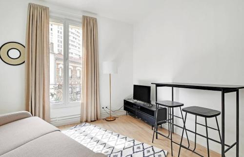 un salon avec un canapé, une table et une télévision dans l'établissement MyKeypers - Lovely Studio 2P - Malakoff 12, à Malakoff