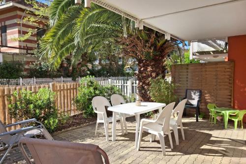 d'une terrasse avec une table et des chaises blanches. dans l'établissement Studio Pinasse - Welkeys, à Arcachon