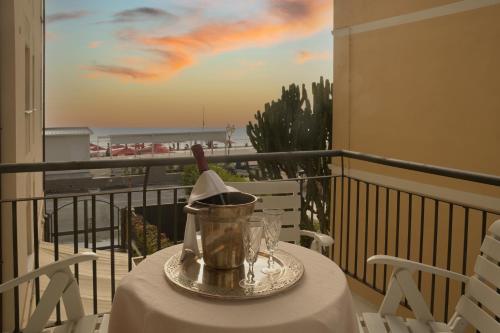 a table with a drink on a balcony with a view at Residence Atlantic in Alassio
