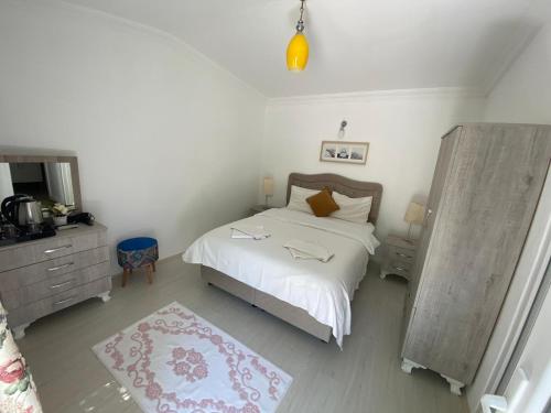 a bedroom with a white bed and a mirror at Tolga Pansiyon in Dalyan