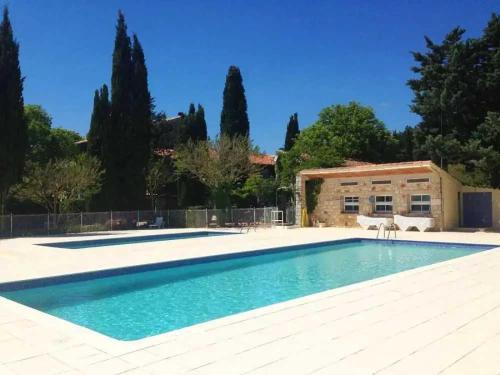 a swimming pool in front of a building with trees at Camping - Piscine - ccbbaah in Quinson