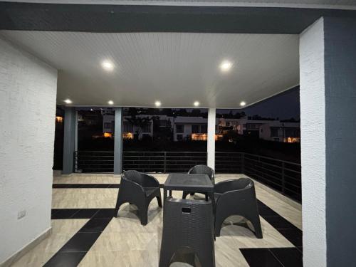 a patio with a table and chairs on a balcony at ISARO Estate in Kigali