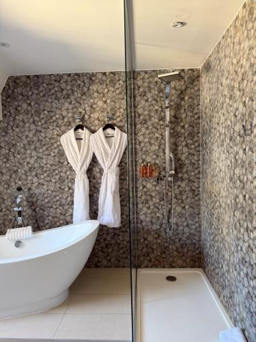 a bathroom with a shower and a tub and a sink at Hôtel Le Rohan, centre Cathédrale in Strasbourg