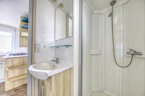 a bathroom with a sink and a shower at Mobilhome Camping Siblu les Viviers in Lège-Cap-Ferret