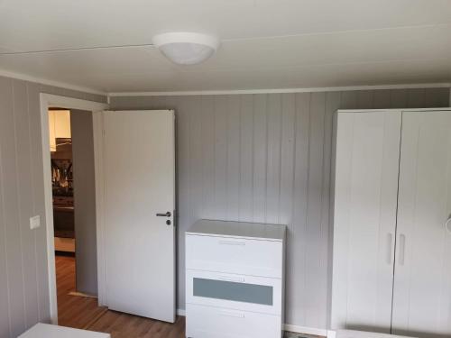 a kitchen with a white stove and a white cabinet at Room with shared kitchen and bathroom nr 3 in Tromsø