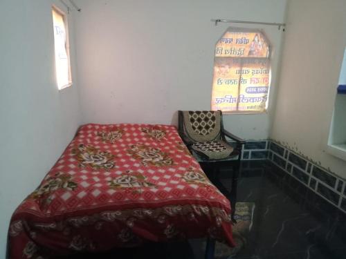 a bedroom with a bed and a window and a chair at Kumar Homestay in Kākora