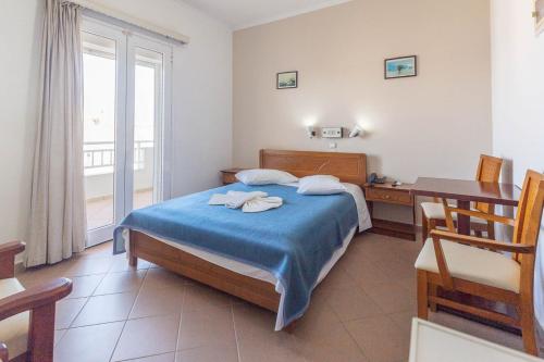 a bedroom with a bed and a desk and a window at Ξενοδοχείο Βεργίνα in Oikonomiánika