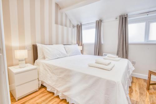 a bedroom with a white bed with two towels on it at Spacious City Center 2 Bed Apartment Free Wifi in Lincoln