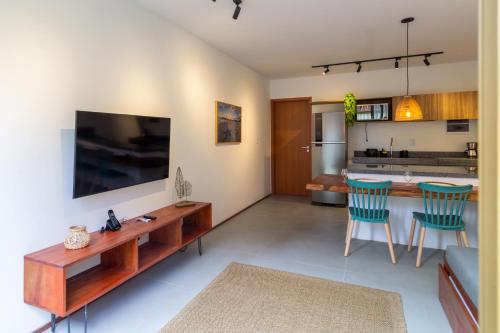 a living room with a table and a kitchen at Villa Naluri - Casa Yodo - Apartamento 1 quarto em Japaratinga in Japaratinga