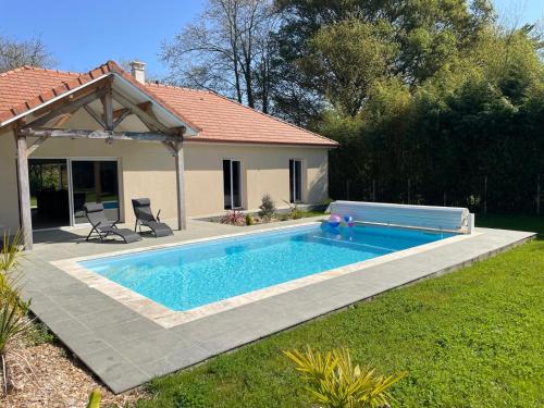 une piscine dans une cour à côté d'une maison dans l'établissement Le chant du Gave- Maison neuve lumineuse avec piscine- Rivière en contrebas du jardin, à Sauveterre