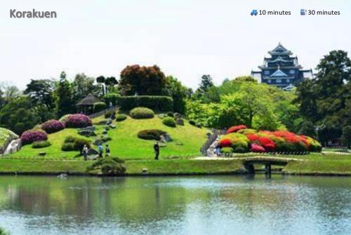 a garden with flowers and a pond and a building at 東横のヨコ in Okayama