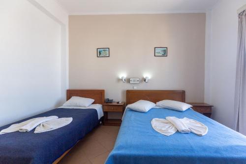 two beds in a hotel room with towels on them at Ξενοδοχείο Βεργίνα in Oikonomiánika