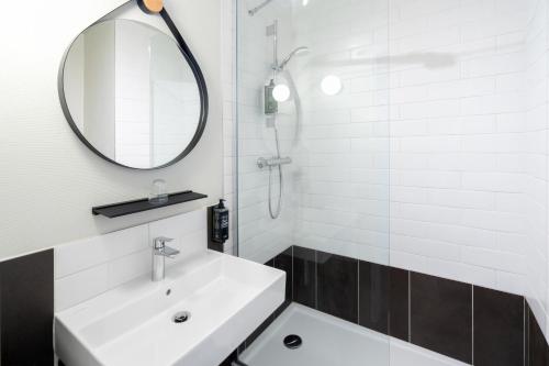a white bathroom with a sink and a mirror at ibis Epernay Centre Ville in Épernay