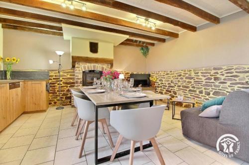 une cuisine et une salle à manger avec une table et des chaises dans l'établissement Du bonheur a la campagne, à Mauron