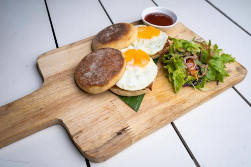 a wooden cutting board with three eggs and a salad at Lub d Siem Reap - Near Pub Street & Angkor Wat in Siem Reap