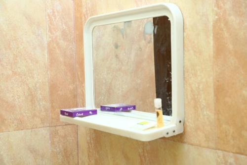 a mirror on a wall in a bathroom at Shiva Nest in Tiruchchirāppalli
