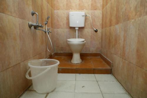a bathroom with a toilet and a bucket at Shiva Nest in Tiruchchirāppalli