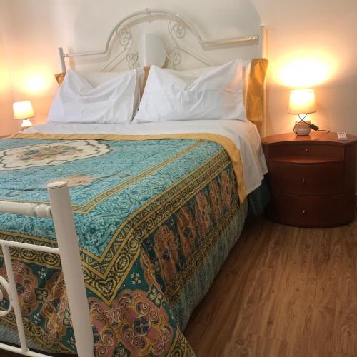 a bed in a hotel room with two lamps at Casa Dorina, la tua casa fuori casa, a 100 m dal mare in Donnalucata