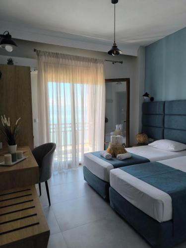 a hotel room with two beds and a table at Maria rooms to let Ouranoupoli in Ouranoupoli