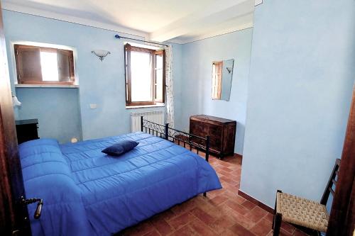 a blue bedroom with a bed and a chair at Agriturismo Caliano in Asciano