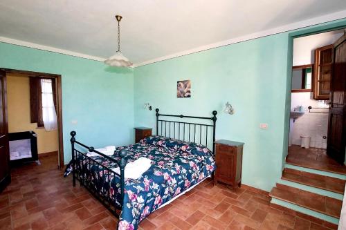 a bedroom with a bed in a room with blue walls at Agriturismo Caliano in Asciano