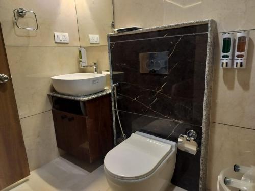 a bathroom with a white toilet and a sink at Indrakeel in Gangtok