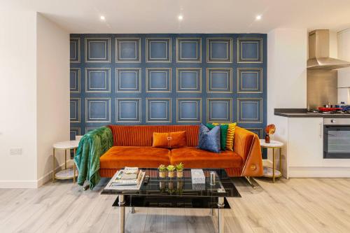 a living room with a couch and a blue wall at Brand New Modern, The Chic Nexus Apartment Central Headington in Oxford