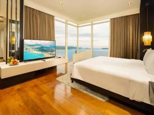 a bedroom with a large white bed and a large window at The Costa Nha Trang Residences in Nha Trang