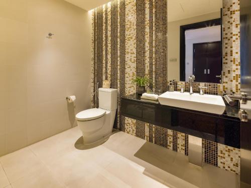 a bathroom with a toilet and a sink at The Costa Nha Trang Residences in Nha Trang