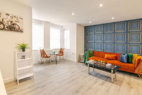 a living room with a orange couch and a table at Brand New Modern, The Chic Nexus Apartment Central Headington in Oxford