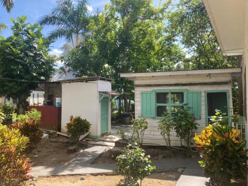 a small house with green and white doors and trees at Yoga Dreams Negril in Negril