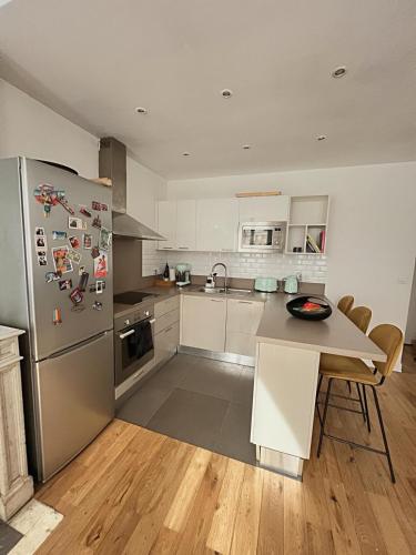une cuisine avec un réfrigérateur en acier inoxydable et une table dans l'établissement Duplex cosy au cœur de Paris, à Paris