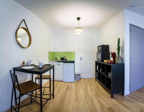 - une petite cuisine avec une table et un comptoir dans l'établissement Confortable studio 2 Pers wifi, à Saint-Quentin