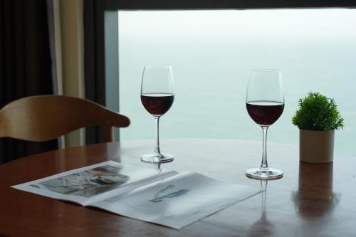 zwei Gläser Rotwein auf einem Tisch in der Unterkunft S Lux Apartment Starcity with Sea View in Nha Trang