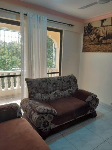 a living room with a couch and a window at aphyl homes in Mombasa