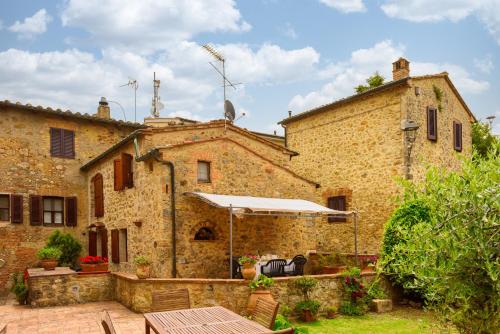 un antiguo edificio de piedra con una mesa y una sombrilla en Mensano Suite by MMega, en Mensano