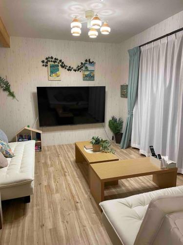 a living room with a large flat screen tv at アイボリーハウス-海徒歩2分秘密の屋根裏部屋焼き鳥屋1分ガスバーベキュー無料ペット同伴可 in Kujukuri