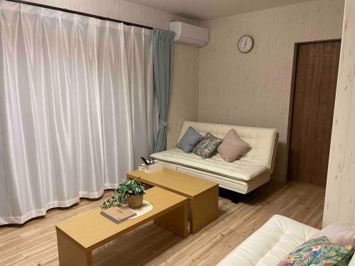 a living room with a couch and a table at 2-minute walk to the sea, a secret base that children can also enjoy, beautiful high-ceiling beams, free gas BBQ rental, detached villa in Kujukuri
