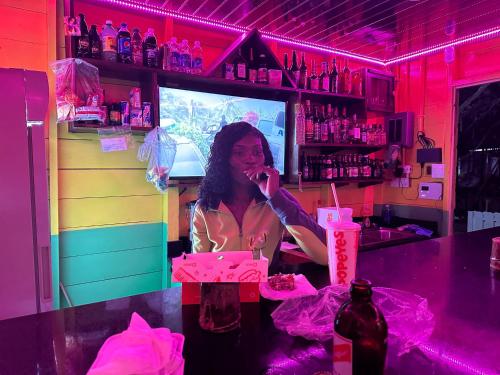 a woman talking on a cell phone in a bar at Yoga Dreams Negril in Negril