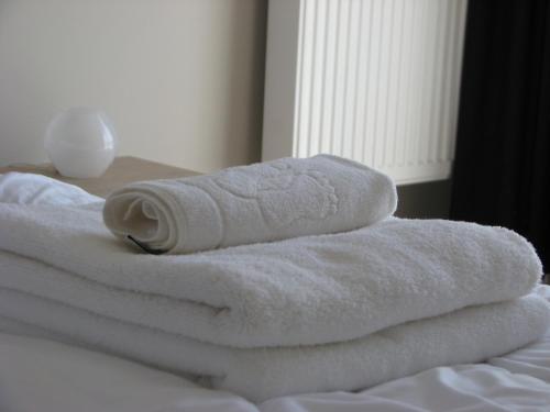 stos ręczników leżący na łóżku w obiekcie Apartament w centrum Gdyni II w mieście Gdynia