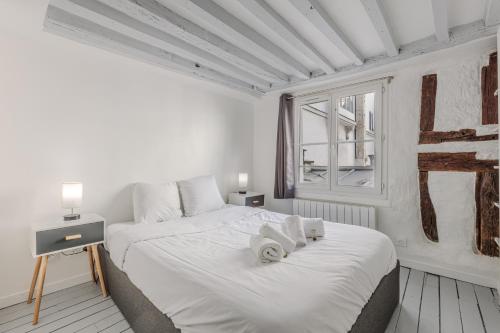 une chambre blanche avec deux lits et une fenêtre dans l'établissement Apartment Cosy 3P Quartier République, à Paris