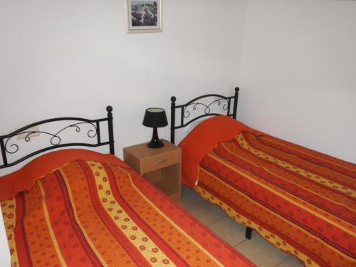 - 2 lits dans une chambre avec une lampe sur une table de chevet dans l'établissement vacances en provence cyprès, à Mormoiron