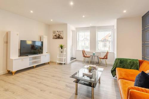 a living room with a couch and a tv and a table at Brand New Modern, The Chic Nexus Apartment Central Headington in Oxford